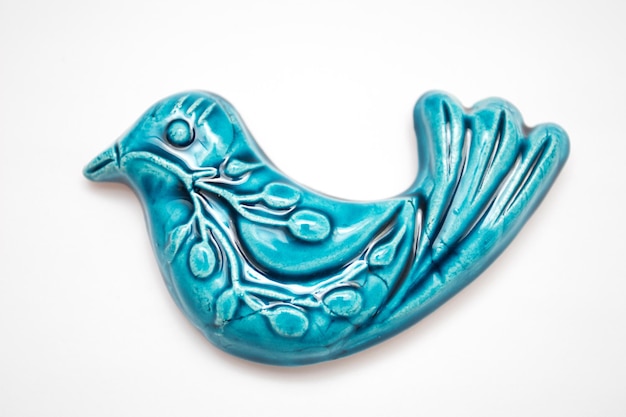 Uma estatueta de um pássaro de cerâmica azul. O pássaro azul é um símbolo de felicidade