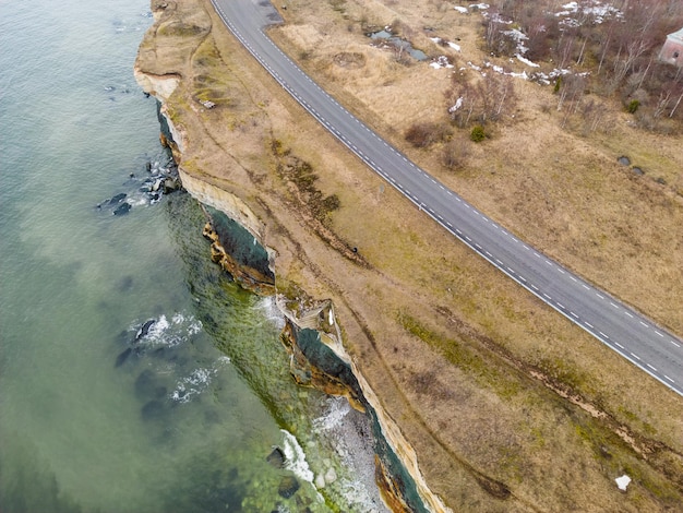 Uma estrada ao longo da água com algas verdes ao lado