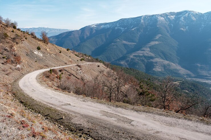 Foto uma estrada nas montanhas com uma montanha ao fundo