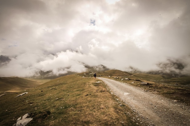 Uma estrada nas nuvens com uma pessoa caminhando ao fundo