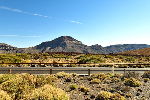 Uma estrada no deserto com montanhas ao fundo