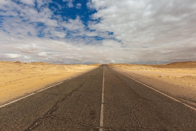 Uma estrada que atravessa o deserto preto e branco no Egito. África
