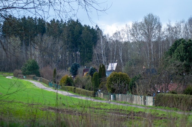 Uma estrada que leva a uma casa com uma cerca ao fundo