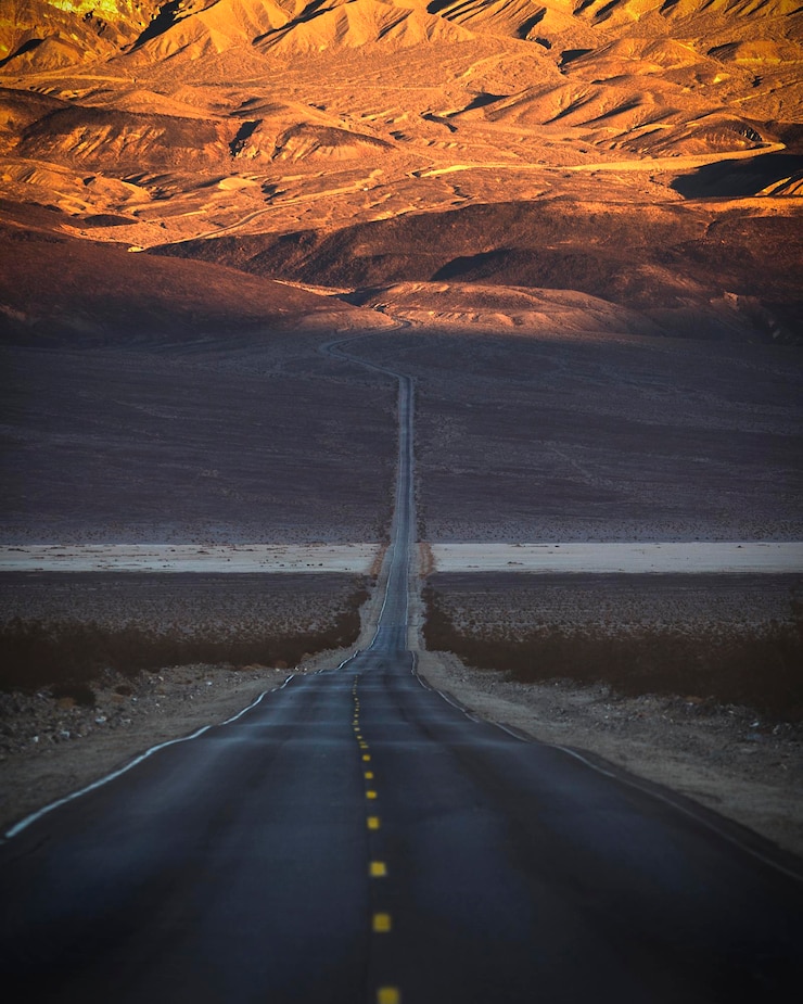 Foto uma estrada vazia que leva à montanha.
