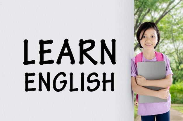 Uma estudante bonita apoia-se na palavra de Aprender Inglês