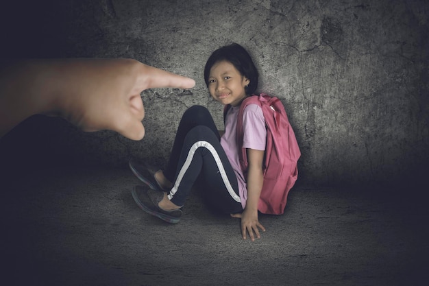 Foto uma estudante triste a ser repreendida pelo professor.