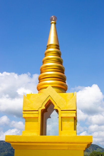 Uma estupa dourada no topo de uma montanha em um templo budista contra uma religião e tradições de céu azul