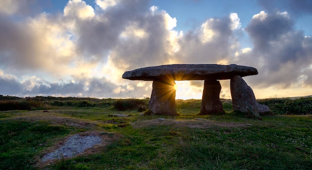 Uma explosão de sol brilhando através de tLanyon Quoit, um antigo dólmen neolítico na Cornualha