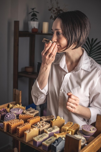 Uma fabricante de sabão mulher segura um sabão de café feito à mão em suas mãos um monte de diferentes pedaços cortados