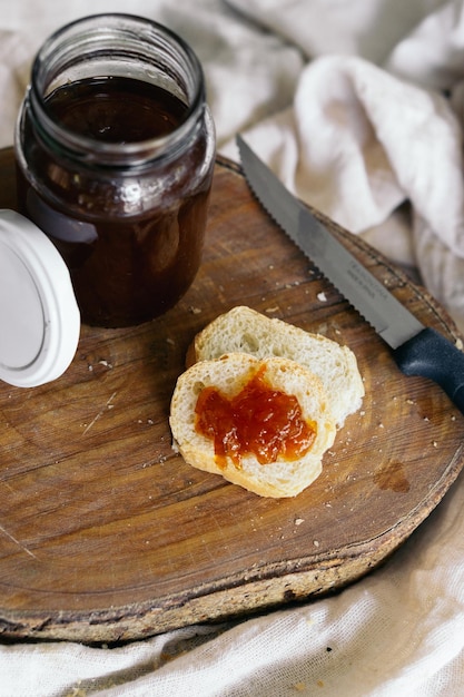 Uma faca ao lado de um pedaço de pão com geléia