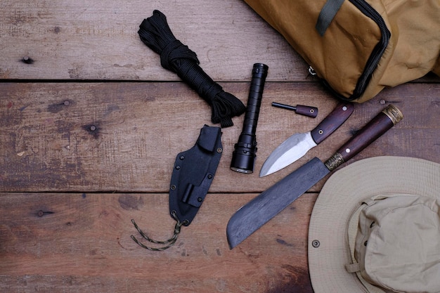 Uma faca com equipamento para sobrevivência na floresta em um antigo piso de madeira