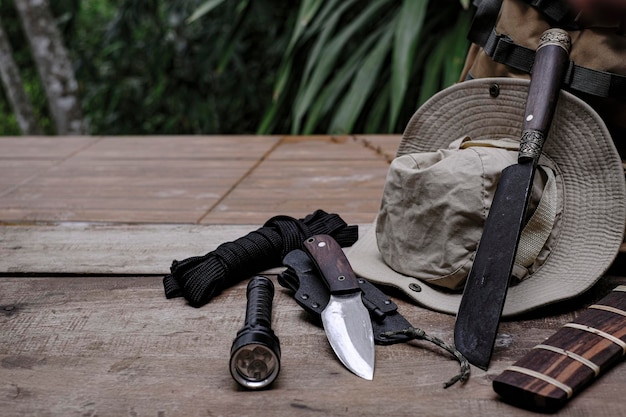 Uma faca com equipamento para sobrevivência na floresta em um antigo piso de madeira