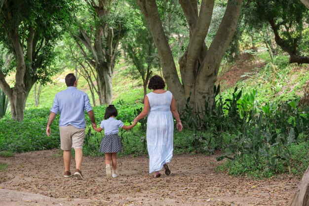 Foto uma família caminha por um caminho na floresta