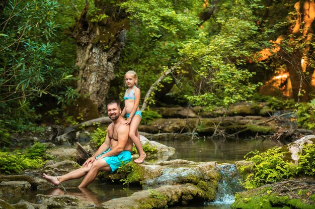 Uma família de pai e filha em um rio de montanha na selva. turquia.