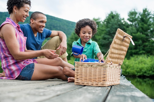 Uma família fazendo um piquenique de verão em um lago