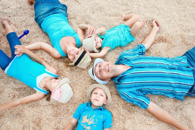 Uma família feliz brincando à beira-mar no fundo de areia