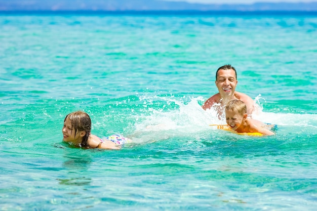 Uma família feliz brincando na água no mar