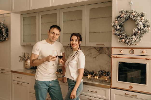 Uma família feliz de três em jeans e camisetas brancas posa em locais de Ano Novo