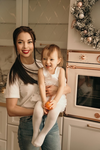 Uma família feliz de três em jeans e camisetas brancas posa em locais de Ano Novo