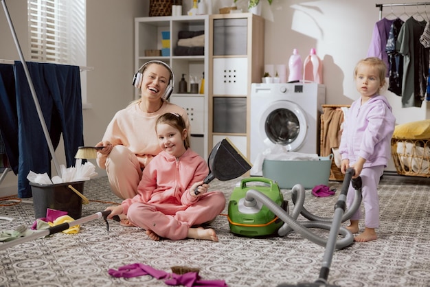 Uma família feliz está limpando um quarto, a mãe e as filhas estão limpando a casa