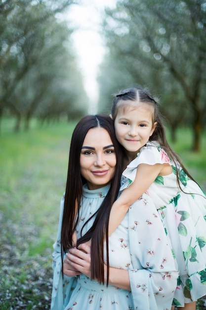 Foto uma família feliz mãe e filha descansam no parque de vestidos