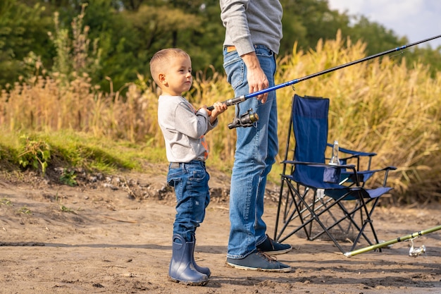 Uma família feliz passa tempo juntos; eles ensinam o filho a pescar.