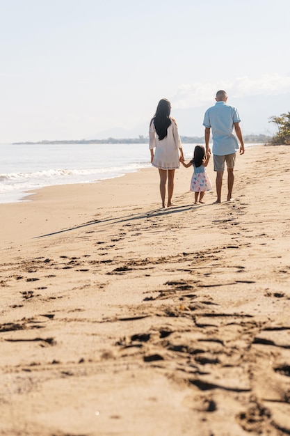 Uma família reunida caminhando na praia