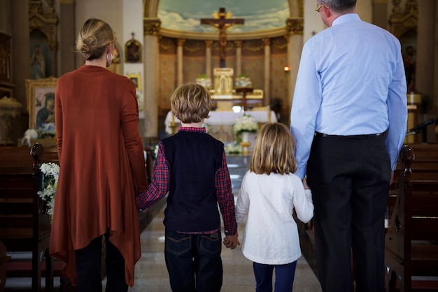 Uma família rezando juntos dentro de uma igreja