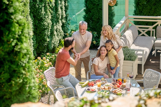 Uma família sentada à mesa de jantar junta