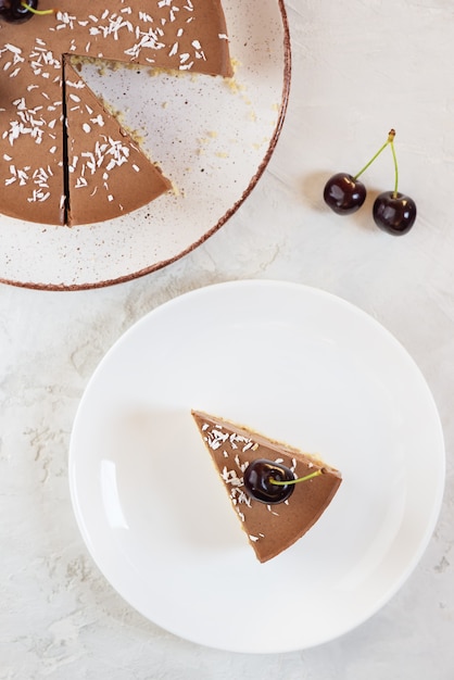 Uma fatia de bolo de mousse de chocolate cru com cerejas