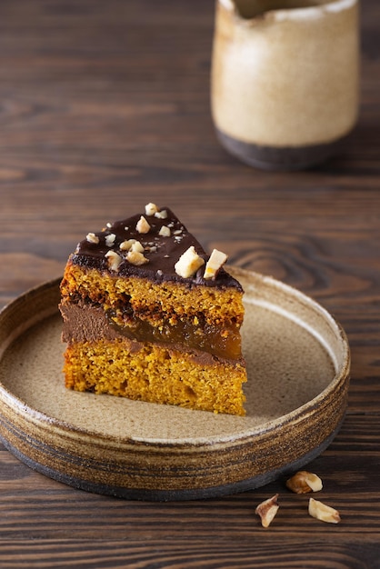 Uma fatia de torta de abóbora americana com laranja em uma mesa de madeira marrom. Açúcar, sem glúten, sem lactose.