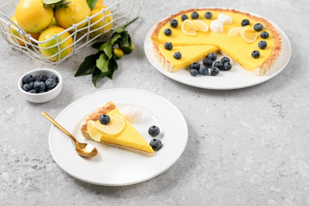 Uma fatia de torta de limão com mirtilos em um prato branco