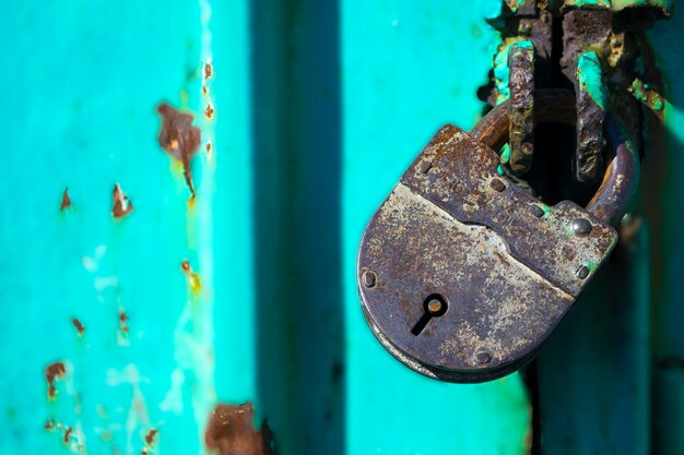 Uma fechadura de ferro fechada na porta rompida de grãos de uma velha casa de campo antiga fechadura de castelo ...