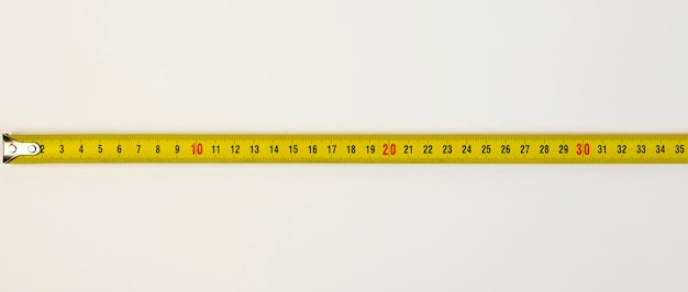 Foto uma ferramenta para medir comprimento fita métrica de construção em um fundo branco