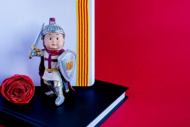 Uma figura de brinquedo com um escudo e uma espada em cima de um livro Coração apaixonado com o catalão