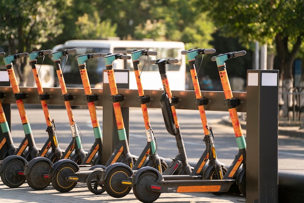 Uma fila de scooters estacionadas na calçada da cidade, veículo elétrico