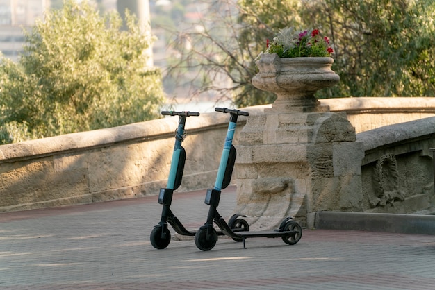 Uma fila de scooters estacionadas na calçada da cidade, veículo elétrico