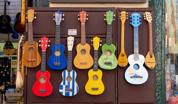 Uma fileira de ukuleles é exibida em uma parede.