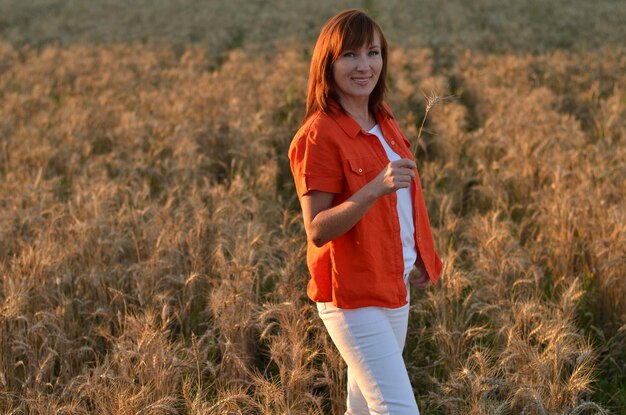 uma filha e uma mãe em um campo com trigo estão sorrindo e falando descuidadamente