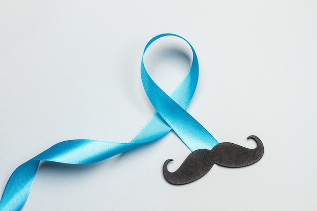 Uma fita azul e um bigode preto em um fundo preto cinza