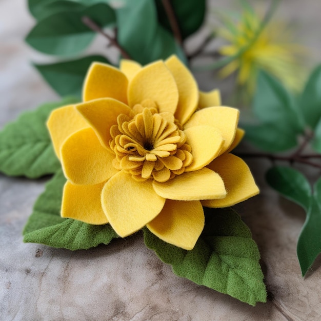 Uma flor amarela feita de feltro com folhas verdes e uma flor.