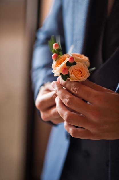 Uma flor na lapela nas mãos dos homens antes do casamento 4255