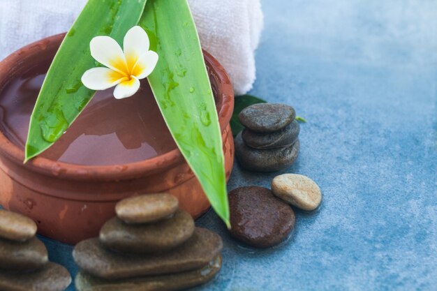 Uma flor tropical e objetos de spa e pedras para salão de massagem