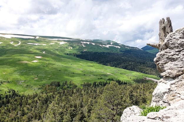 Uma floresta ao lado das rochas com vista para os prados alpinos O planalto LagoNaki na Adygea Rússia 2021