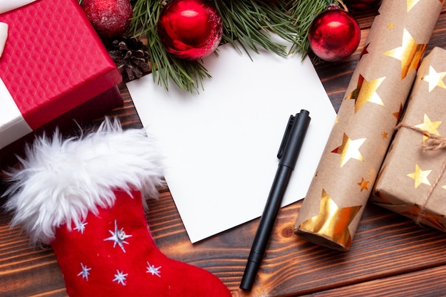 Uma folha branca em branco para carta ou lista em uma mesa de madeira com decorações de natal de ano novo