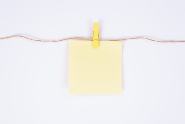 Uma folha de papel com lugar para texto pendurado em uma corda anexa com pings de design isolado de fundo branco