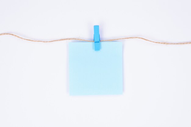 Uma folha de papel com lugar para texto pendurado em uma corda anexa com pings de design isolado de fundo branco