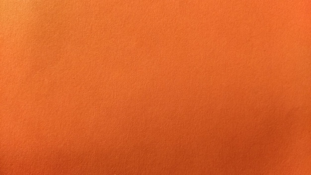 Uma folha de papel grosso de cor laranja brilhante Plano de fundo sombra intensa Iluminação lateral natural Papelão fino ou textura de papel Gradiente de luz em grau de iluminação