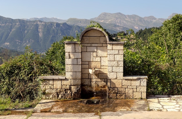 Uma fonte de pedra fechada com água fria e clara nas montanhas em uma região ensolarada de verão Tzoumerka Grécia montanhas Pindos