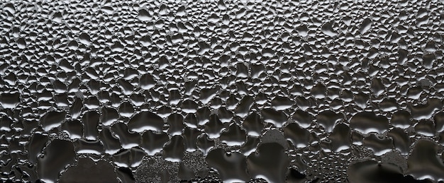 Uma foto da superfície de vidro da janela, coberta com uma infinidade de gotículas